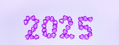 New Year 2025 inscription from glass hearts on a violet background. Pantone color 2025. Idea and creativity. Valentines Day. Christmas with loved ones. Horizontally, banner.の写真素材