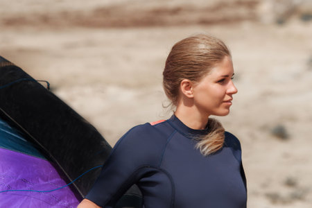 A woman with a multicolored parachute, an athlete riding kitesurfing on a blue shore. Beach, active recreation. Sunset, parachute, board, freedom.の写真素材