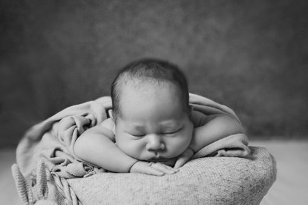 A newborn baby is wrapped in a blanket. A mothers love for her child.の写真素材