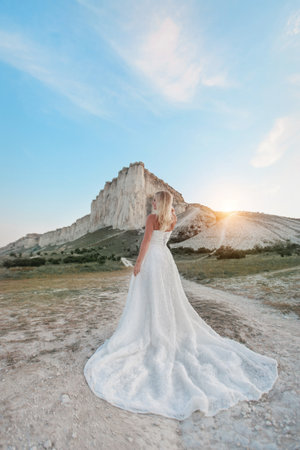 a woman in a white dress, a bride on a mountain with a blue sky. Beautiful nature, freedom, enjoyment of life.の写真素材