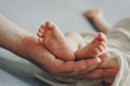 Moms arms hug the baby. the legs of a newborn. the heels, the fingers of a baby, a child. family, love.の写真素材