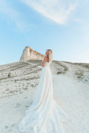a woman in a white dress, a bride on a mountain with a blue sky. Beautiful nature, freedom, enjoyment of life.の写真素材