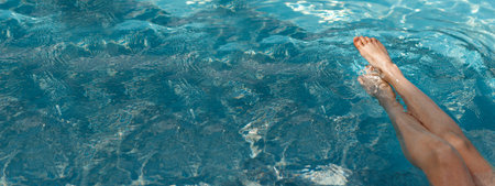 A girls feet in a blue pool. Epilation of legs, varicose veins. Rest, relaxation on the beach, at...