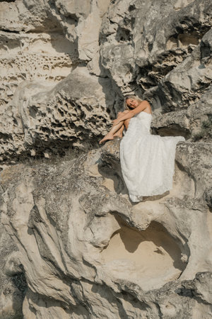 a woman in a white dress, a bride on a mountain with a blue sky. Beautiful nature, freedom, enjoyment of life.の写真素材