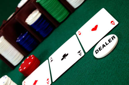 cards and stack of Poker chips and dealer button on a green background