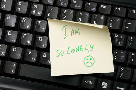 Sticky note on a laptop keyboard with  I am so lonely  の写真素材