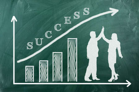 Chart on green blacboard,man and woman in successの写真素材