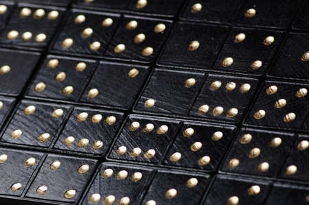 background made of black domini with golden dots  closeupの写真素材