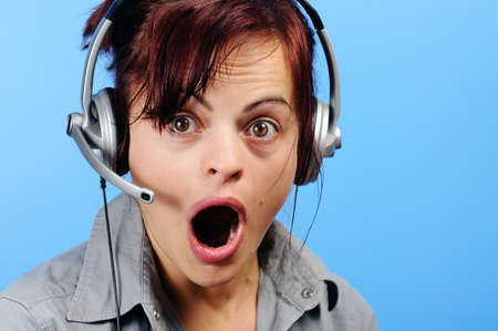 Beautiful young customer assistant wearing a headset with surprised lookの写真素材