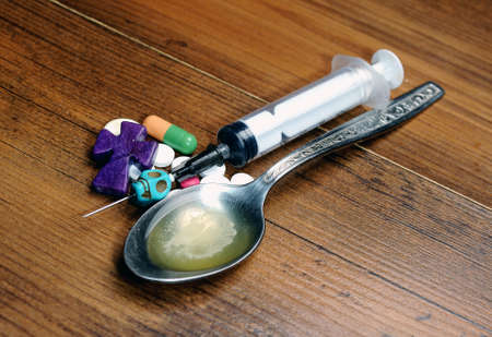 Drug abuse- syringe , spoon,skul,cross  and lighter on the floorの写真素材