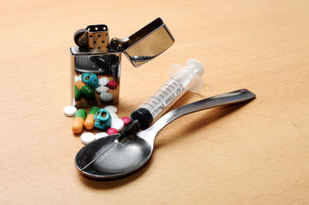 syringe, spoon,pills,skull  and lighter on the floorの写真素材