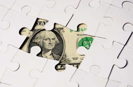 Dollar hidden under  Puzzle, business concept of Solution- close upの写真素材