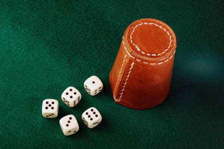 dices  and leather a cup on green cloth の写真素材