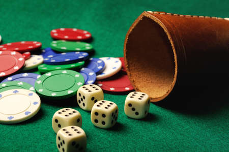 Poker dice with chips on green casino tableの写真素材