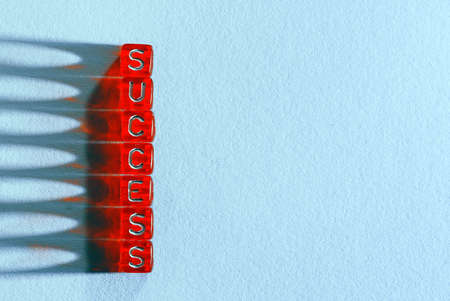 Success , written on red cubes on blue papper  background and lighting effectの写真素材