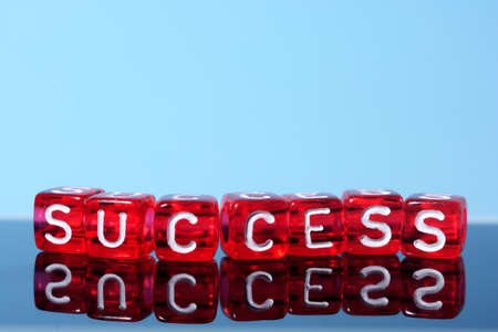 Success  text  written  on red cubes on blue  backgroundの写真素材