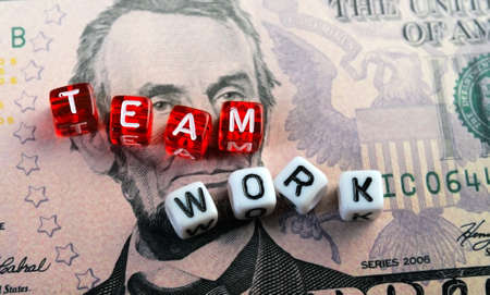 dices  with text  TEAMWORK on five dollar banknoteの写真素材