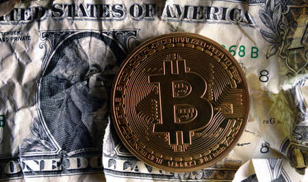 Bitcoin on Crushed dollar banknote.Concept of  Monetary system collapse .