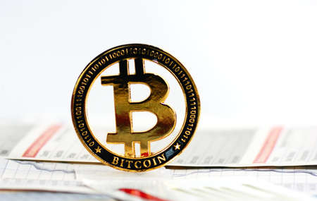A golden bitcoin on graph and diagrams on white  background. の写真素材