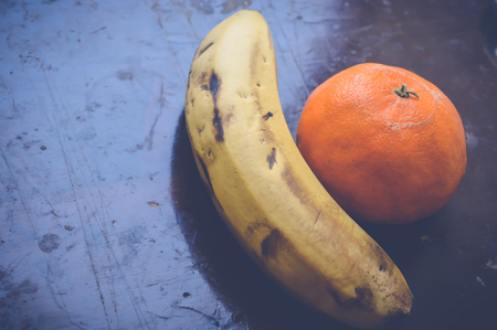 banana and tangerine on wooden tableの写真素材