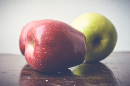 red and green apples on wooden tableの写真素材
