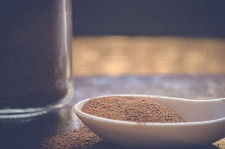 cinnamon on white spoon and in jar on wooden tableの写真素材
