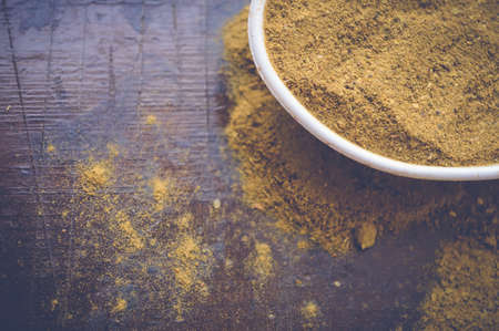 curry powder on white spoon on wooden tableの写真素材