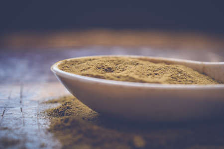 curry powder on white spoon on wooden tableの写真素材