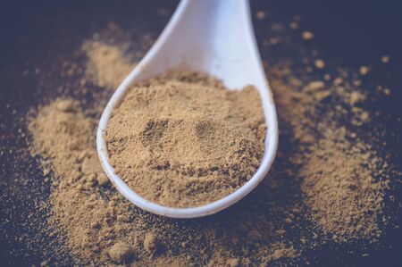 ginger powder on white spoon on wooden tableの写真素材