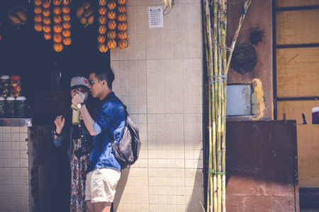 cairo, egypt, april 15, 2017: asian tourists drinking sugar cane juice at muizz street