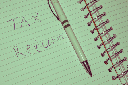 tax return hand written on note paper with pen, financial conceptの写真素材