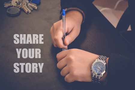 share your story on wooden table, businessman hands in officeの写真素材