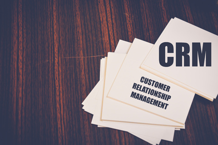 crm written on notepaper on wooden table, customer relationship management conceptの写真素材