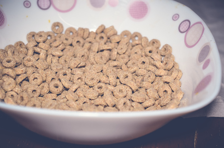 corn flakes in a bowl on wooden tableの写真素材