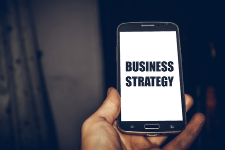 Business strategy written on mobile phoneの写真素材