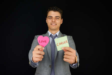 Businessman trying to balance love and career conceptの写真素材