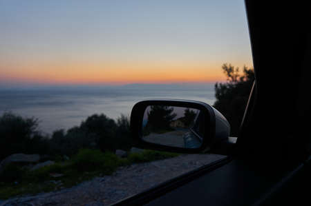 A view from a car window at sunset over the seaの写真素材