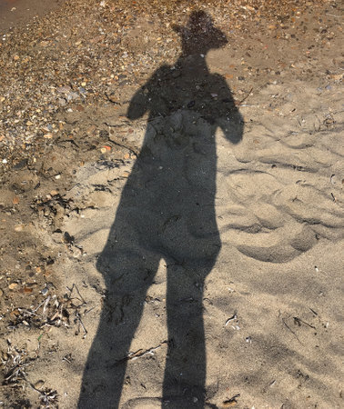 Shadow of a man with hat at the beachの写真素材