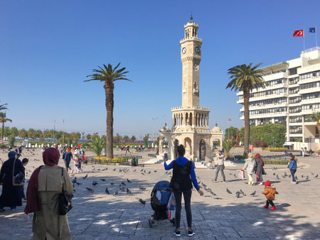 Izmir, Turkey - November 11, 2020: Doves and walking people on Konak Square near the historical and famous clock tower.のeditorial素材