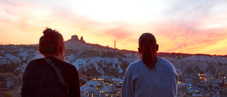 Goreme, Cappadocia / Turkey - October 24, 2020: Panoramic cityscape photo of Goreme Town in Nevsehir, Turkey. Tourists looking at the wonderfull sunset view.のeditorial素材