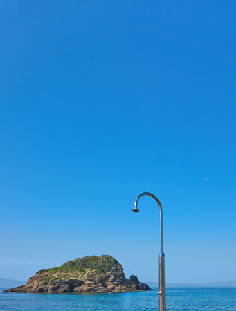 Shower on the beach with an island in backgroundの写真素材