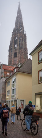 Freiburg, Germany - December 22, 2025:The famous city during the Christmas season. Festive atmosphere with historic architecture and everyday city life visible.Freiburg Minster with daily market in city centerのeditorial素材