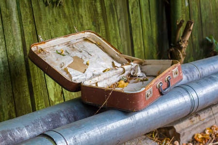 old abandoned suitcase lies on the pipesの写真素材