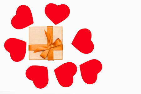 gift box with Golden ribbon and some red hearts around on white background. festive concept for Valentine's day, birthday, wedding, party, holidayの写真素材