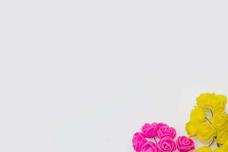 pink and yellow artificial roses on a white background. festive concept for Valentine's day, birthday, wedding, party, holidayの写真素材