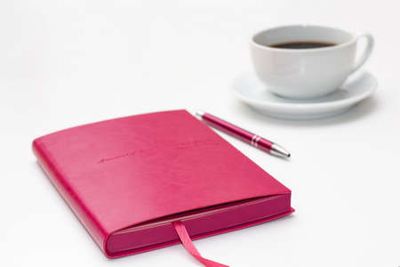 pink diary with pen and a Cup of black coffee on white. business minimal concept for women.の写真素材