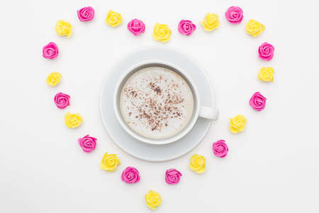 Cup of black coffee pink yellow roses laid out in the shape of a heart on a white background. romantic love background for Valentine's day, birthday, holiday, party, weddingの写真素材