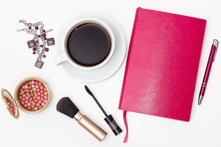 flat lay Cup of black coffee, jewelry, diary with pen, brush for makeup and other accessories on a white background.の写真素材