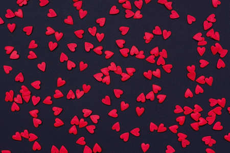 many little red hearts on a black background. festive background for Valentine's day, birthday,...
