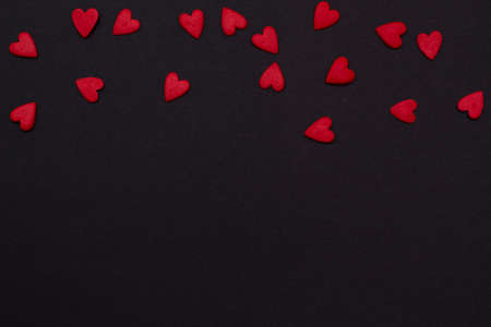 few of little red hearts on top of a black background. festive background for Valentine's day, birthday, holiday.の写真素材